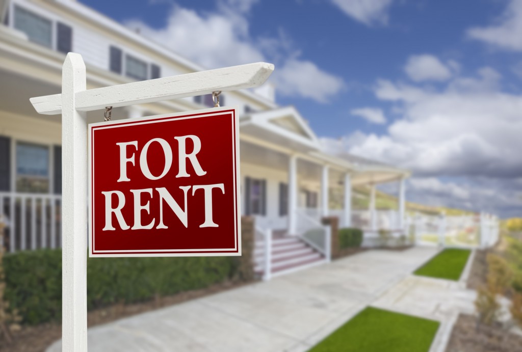 Red For Rent Real Estate Sign in Front of Beautiful House.